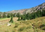 In the upper basin, the trail is well-graded through alpine meadows and steep hillsides.