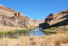 At hike's end, the Owyhee River runs through a coloful, scenic canyon with basalt cliffs.